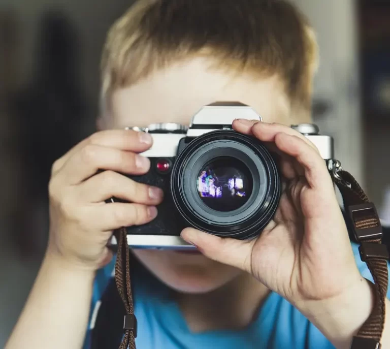 Young boy holding camera